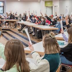 Schülerinnen und Schüler der Albert-Einstein-Schule stimmen bei der fiktiven Ratssitzung im Projekt Pimp your Town über Anträge ab.