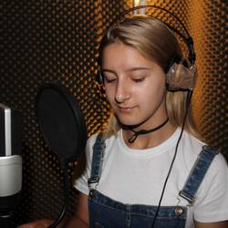 Eine Schülerin der Sprachlernklasse der Albert-Einstein-Schule singt im Tonstudio den Text für den Song ein.