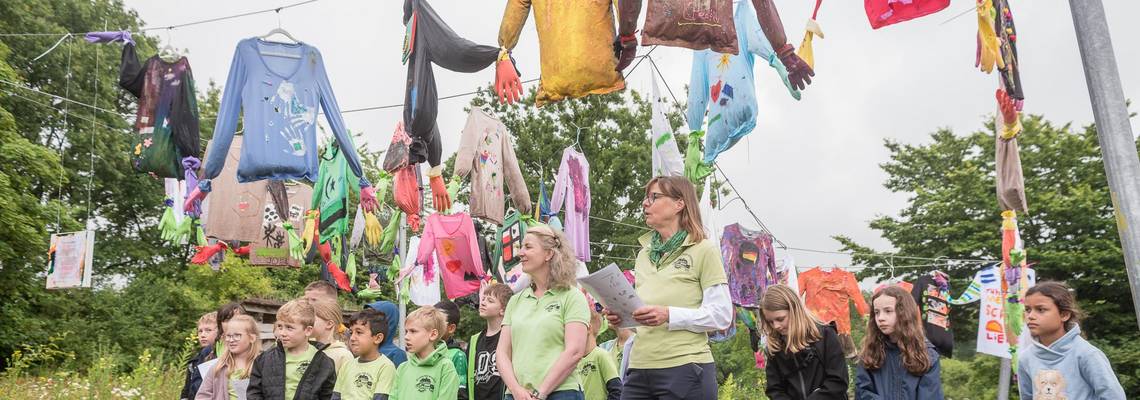 Die Schülerinnen und Schüler aus dem Projekt "Ich + Du = Wir!" stellen ihre Ergebnisse bei der Vernissage am 19. Juni 2024 vor dem Mitmachgarten im Park der Sinne in Laatzen vor.