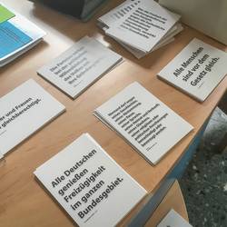 Plakat- und Postkartenaktion Grundgesetz - Die Postkarten liegen an der Information im Laatzener Rathaus zum Mitnehmen bereit