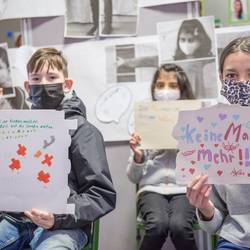 Bei der Abschlusspräsentation des Projektes "Wir entscheiden mit" im Bundesprogramm Demokratie leben! zeigen die beteiligten Schülerinnen und Schüler der Grundschule Im Langen Feld in Laatzen-Mitte Schilder mit ihren Wünschen und Fähigkeiten.