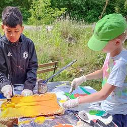 Jungen und Mädchen der Grundschiule Grasdorf erstellen ein Kunstwerk am Mitmachgarten im Park der Sinne.