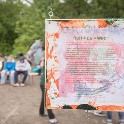 Die Schülerinnen und Schüler aus dem Projekt "Ich + Du = Wir!" stellen ihre Ergebnisse bei der Vernissage am 19. Juni 2024 vor dem Mitmachgarten im Park der Sinne in Laatzen vor.